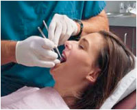 A woman getting her teeth cleaned by a hygienist.